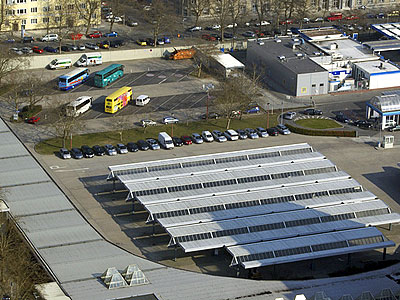 Eine Luftaufnahme eines Parkplatzes mit Fahrzeugen und Solar-Parkplätzen.